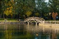 Kremenchuk city, Ukraine - October 7, 2022: Scenic pond in the city garden with an embankment, iron railings and a footbridge
