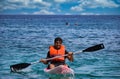 Kreta or Crete Greece - A man in life jacket floating on a kayak in a sea against clouds. Water sport kayaking during summer