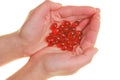 Krill oil capsules. Red gelatin capsules with krill oil in hand on white background.Source of omega fatty acids.Close up