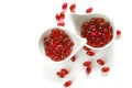 Krill oil red gelatin capsules in white ceramic cups on a white background.omega fatty acids.Healthy eating and food