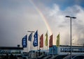 Kronan, Jysk and Bakarameistarinn company flags in front of Husgagnahollin shopping center in Reykjavik. Rainbow in the sky.