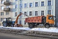 Tractor `Belarus` and dump truck `Mercedes Benz` clean the sidewalk from snow
