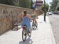 Krosno, Poland - july 9 2018:Two girls in beautiful festive dresses ride on bicycles along the historic streets of the baroque tow Royalty Free Stock Photo