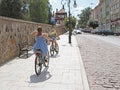 Krosno, Poland - july 9 2018:Two girls in beautiful festive dresses ride on bicycles along the historic streets of the baroque tow Royalty Free Stock Photo