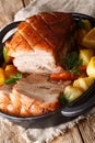 Krustenbraten Pork Roast with Crispy Rind with vegetables close-up in a frying pan. Vertical Royalty Free Stock Photo