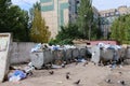 Trash in overloaded garbage bins in courtyard of residential district