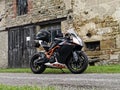 KTM RC8R sports motorcycle in rural France. Old stone building backdrop