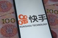 Kuaishou Technology logo seen on the smartphone screen and Chinese yuan banknotes background. Popular Chinese video streaming plat