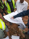 Construction workers discuss among themselves regarding technical issues at the construction site. Royalty Free Stock Photo