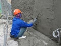 Brick wall plastered by construction workers using the cement plaster.