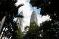 Kuala Lumpur, Malaysia - August 13, 2022: View of the Twin Towers through the palm trees of KLCC Park. Urban oasis with water