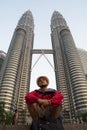 Young Traveler in the  Twin towers Petronas and sky bridge at Mayl 18, 2013, Kuala Lumpur, Malaysia Royalty Free Stock Photo
