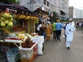 People walking past a greengrocer at the Chow Kit Market in Kuala Lumpur