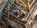 Construction workers pouring wet concrete using concrete spider hose