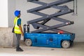 Manual Workers standing at the construction site next to the scissor lift