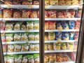 Packed chicken nugget in various brand placed in display chiller refrigerator inside the huge supermarket.