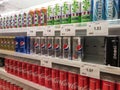 Soft drinks in cans are displayed on a shelf for sale in a large supermarket. Royalty Free Stock Photo