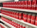 Soft drinks in cans are displayed on a shelf for sale in a large supermarket. Royalty Free Stock Photo