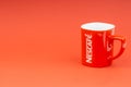 Red Nescafe mug isolate on red background.