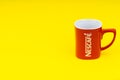 Red Nescafe mug isolate on yellow background