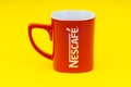 Red Nescafe mug isolate on yellow background