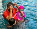 Happy active family father and cute daughter adorable toddler girl playing in a swimming pool Royalty Free Stock Photo