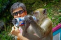 Kuala Lumpur, Malaysia - March 9, 2017: Monkey drinking soda can in the stairs to Batu Caves, a limestone hill with big Royalty Free Stock Photo