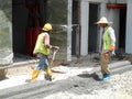 Construction workers creating concrete road curb at the construction site.