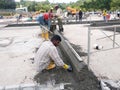 Construction workers creating concrete road curb at the construction site.