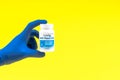 Hand in a blue glove holding multivitamin bottle Royalty Free Stock Photo