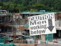 Safety signage `CAUTION - Men Working Below` at the construction site.