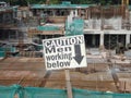 Safety signage `CAUTION - Men Working Below` at the construction site.