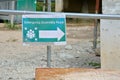 Safety signage `Emergency Assembly Point` with direction arrow at the construction site.