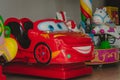 A coin operated kiddie ride Cars cartoon character displayed at the entrance of a store