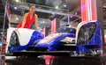 Model posed with Toyota TS030 hybrid racing car produced by Toyota at Toyota booth