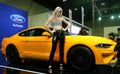 Model posed with yellow Ford Mustang BULLITT 5.0 displayed during Kuala Lumpur