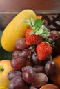 Kuala Lumpur, Malaysia - October 21, 2020 : Assorted fresh fruits in the wooden tray.  strawberry, red grapes, mango, apple and o Royalty Free Stock Photo