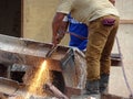 Construction workers cutting steel I beam using blowtorch at construction site.