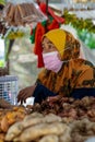 Woman seller wearing face mask at the local ingredients fresh food stall