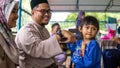 Young Asian Malay kids getting a envelope of money or Duit Raya during the Hari Raya Aidilfitri celebration