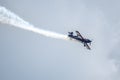 Silhouette of an airplane with trail of smoke behind against background of blue sky Royalty Free Stock Photo