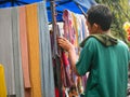 Kudus, Indonesia - January 23 2022 :A male saleman sell a women head scarft at a Street market