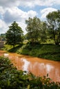 Kuks, East Bohemia, Czech Republic, 10 July 2021: Elbe River after rain with yellow, dark orange water similar to rust at sunny