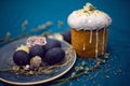 Kulich with sugar glaze .decoration design blue easter eggs lie on a plate with a willow on fabric background. Paska