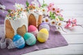 Kulich, traditional Russian Ukrainian Easter cake with icing and colored eggs with lace ribbon on white wooden background Royalty Free Stock Photo