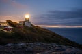 Kullen lighthouse shining its light after sunset. Denmark and sweden in the background