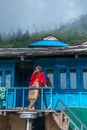 Kullu, Himachal Pradesh, India - September 01, 2018 : woman in balcony of traditional wooden house in mountain