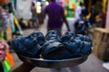 Kumartuli,West Bengal, India, July 2018, An artisan carries freshly made and painted clay heads of Goddess Durga on a dish at Kuma