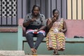 Unidentified Ghanaian women sit on the bench and have lunch.