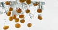 Kumquat, fortunella margarita, Fruits falling into Water against White Background